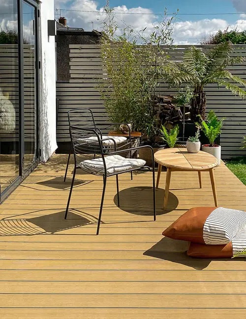 Composite Decking Boards in Teak with coffee table and chairs.