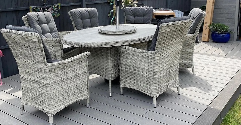 rattan dining set on light grey decking