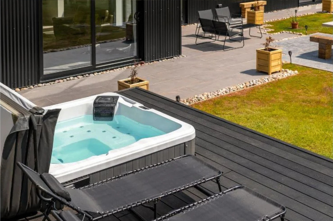 The Black Barn Project uses Cladco Woodgrain Composite Decking in Charcoal for an outdoor hot tub area.
