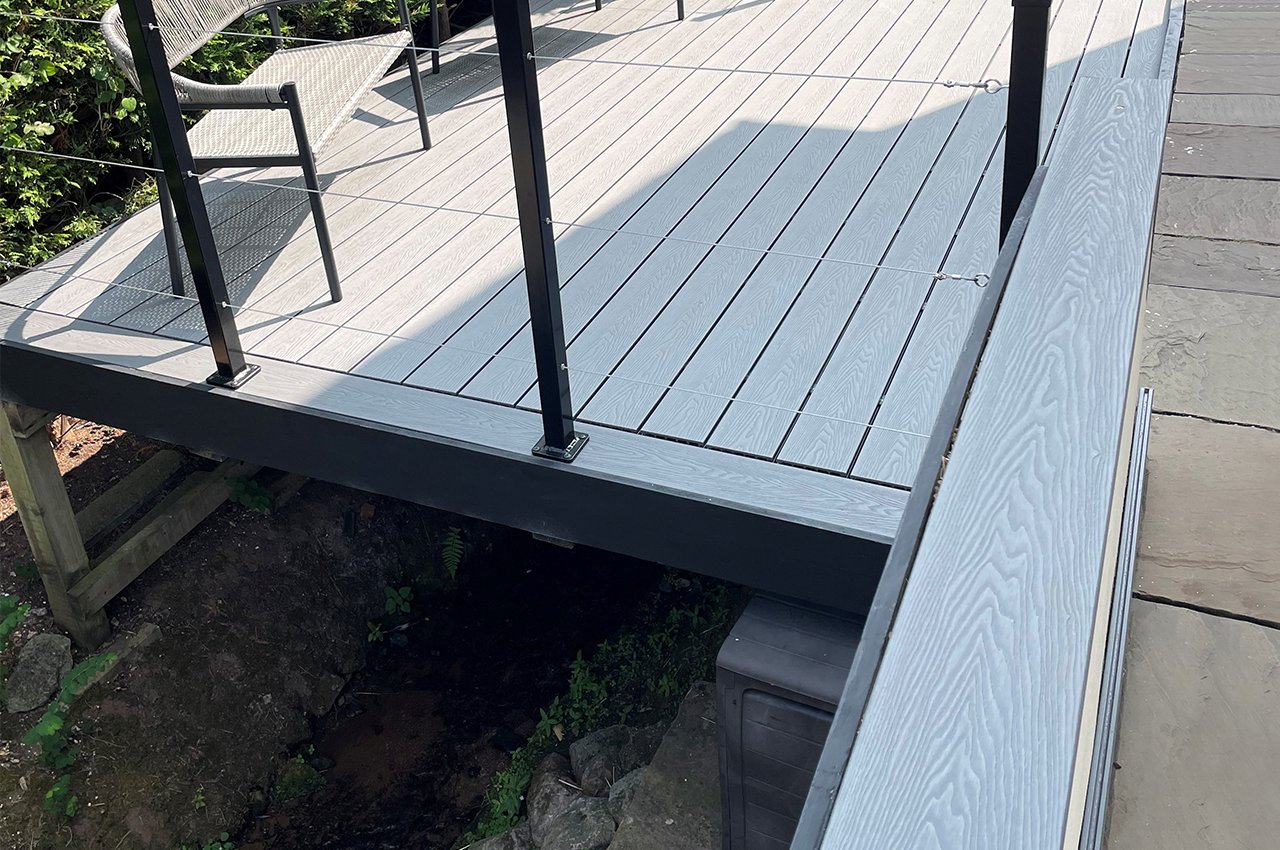 A Unique Outdoor Space With Raised Stone Grey Decking Spanning A Garden Stream