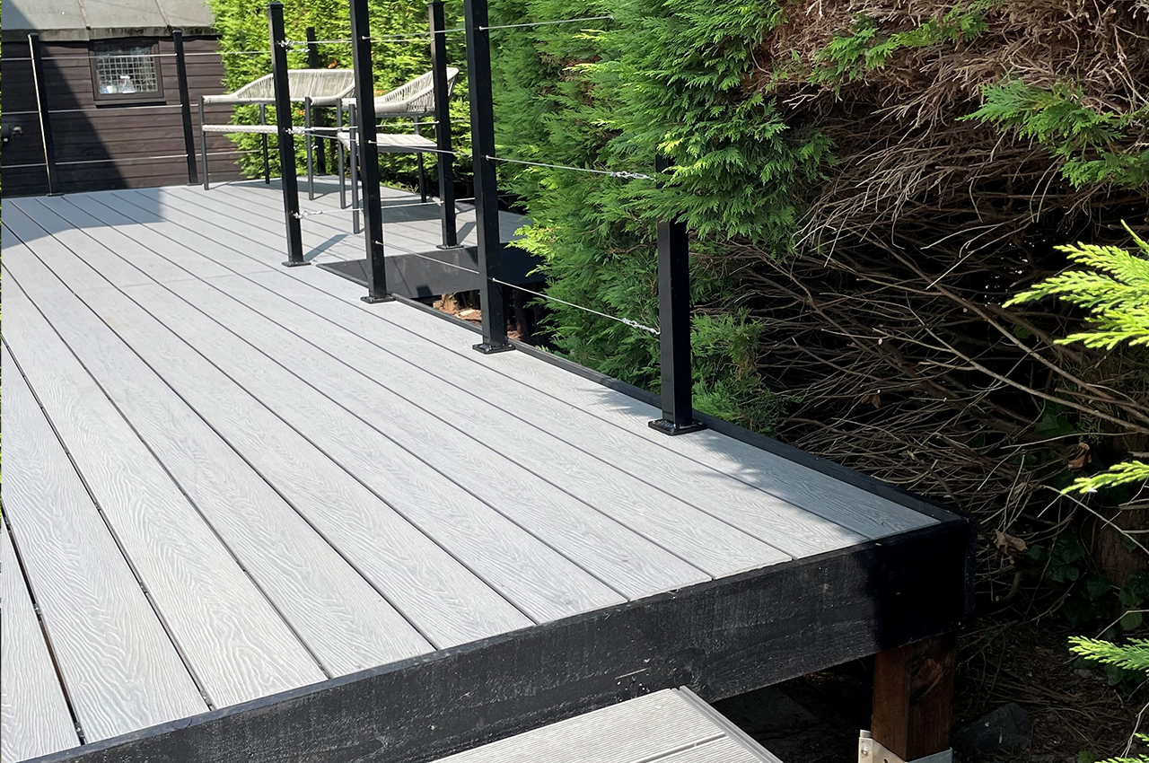 A Unique Outdoor Space With Raised Stone Grey Decking Spanning A Garden Stream