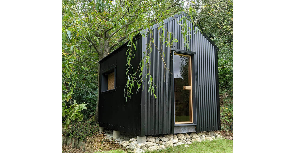 Black Corrugated Cladding Sheets adorn this garden sauna