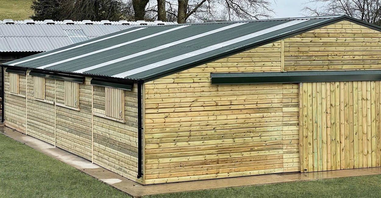 Large barn design by @devonshire_stables using Cladco 32/1000 Roofing Sheets in Juniper Green