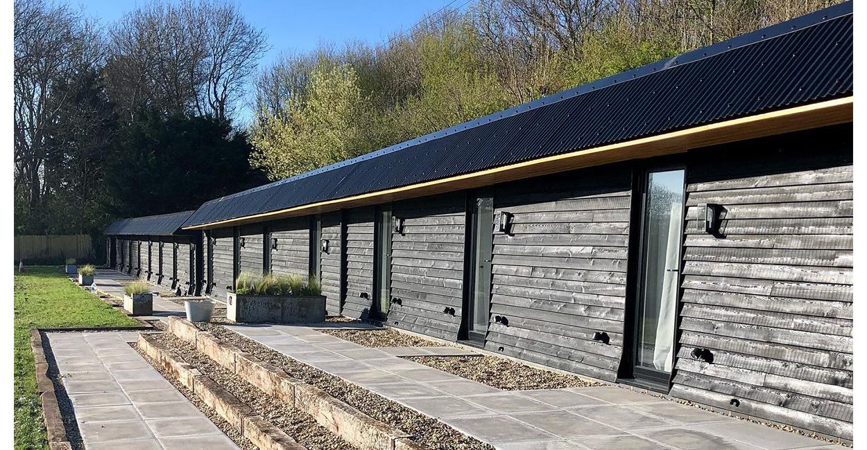 The Hopper Huts rebuild their original farm outbuildings using Cladco Corrugated Roofing Sheets in Black.