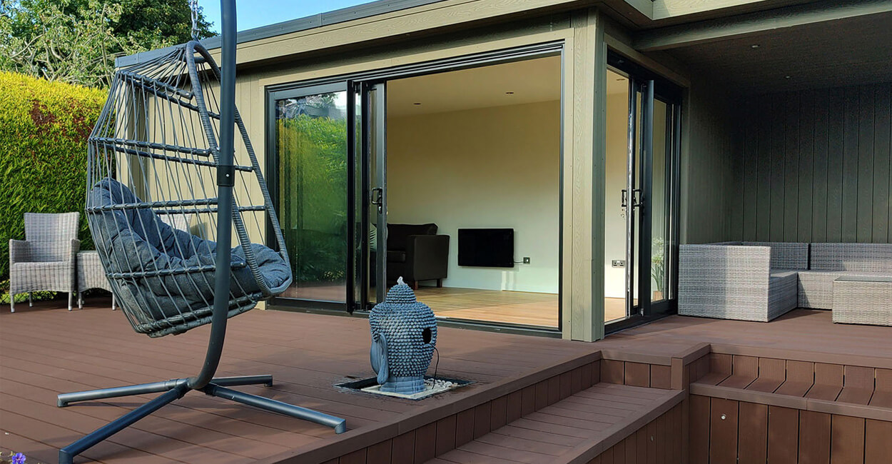 Alt Text: Composite Decking and Cladding used together on a large summer house.