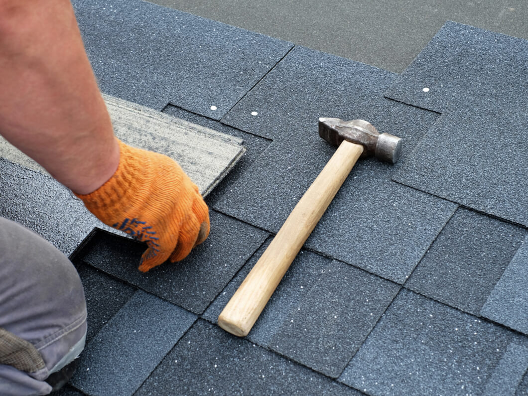 Man fitting roof shingles