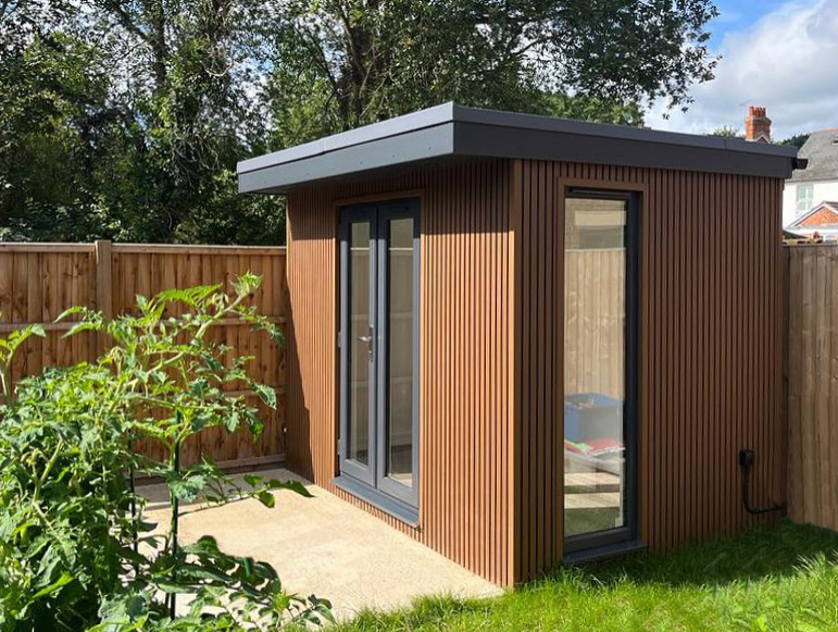Garden room with teak coloured slatted cladding