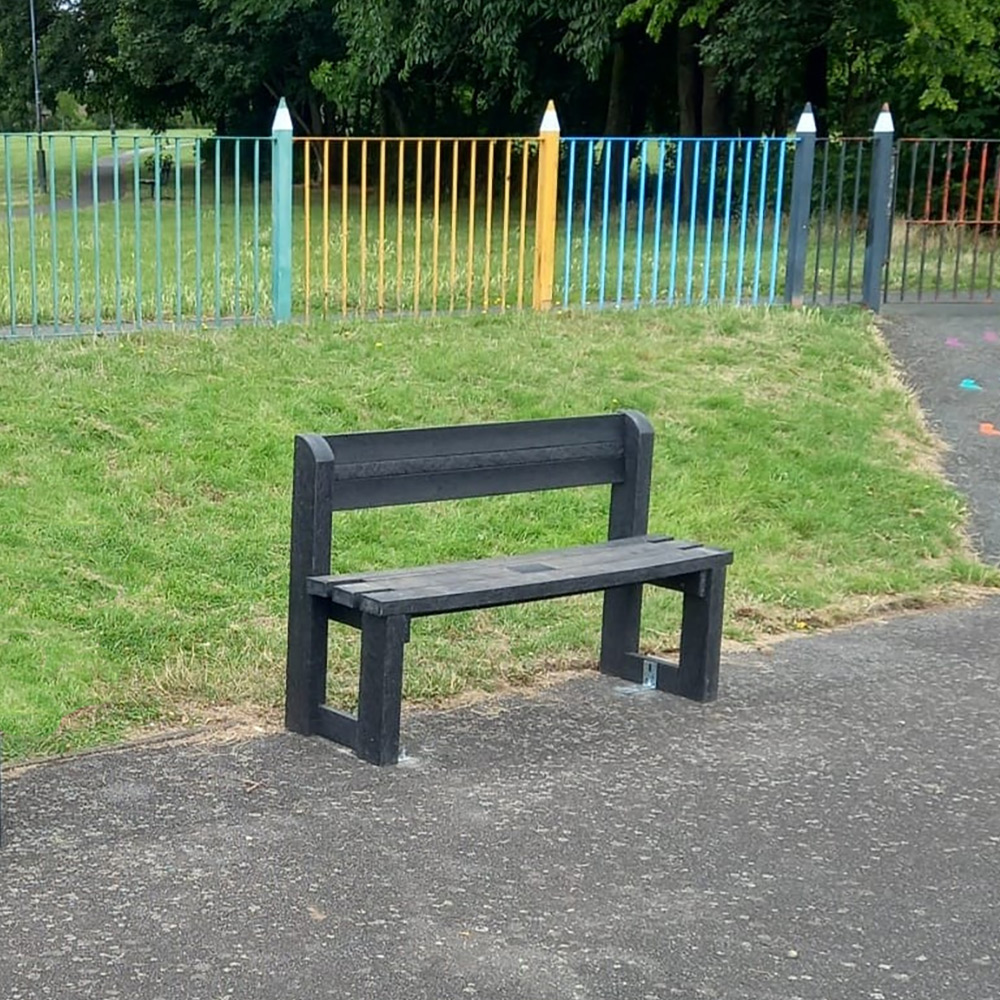 Recycled plastic garden benches installed inside a play park.