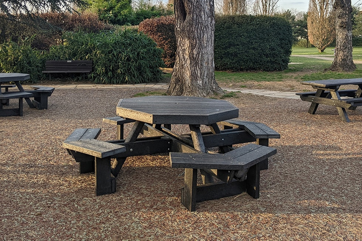 Octagonal, recycled plastic picnic table in a park.