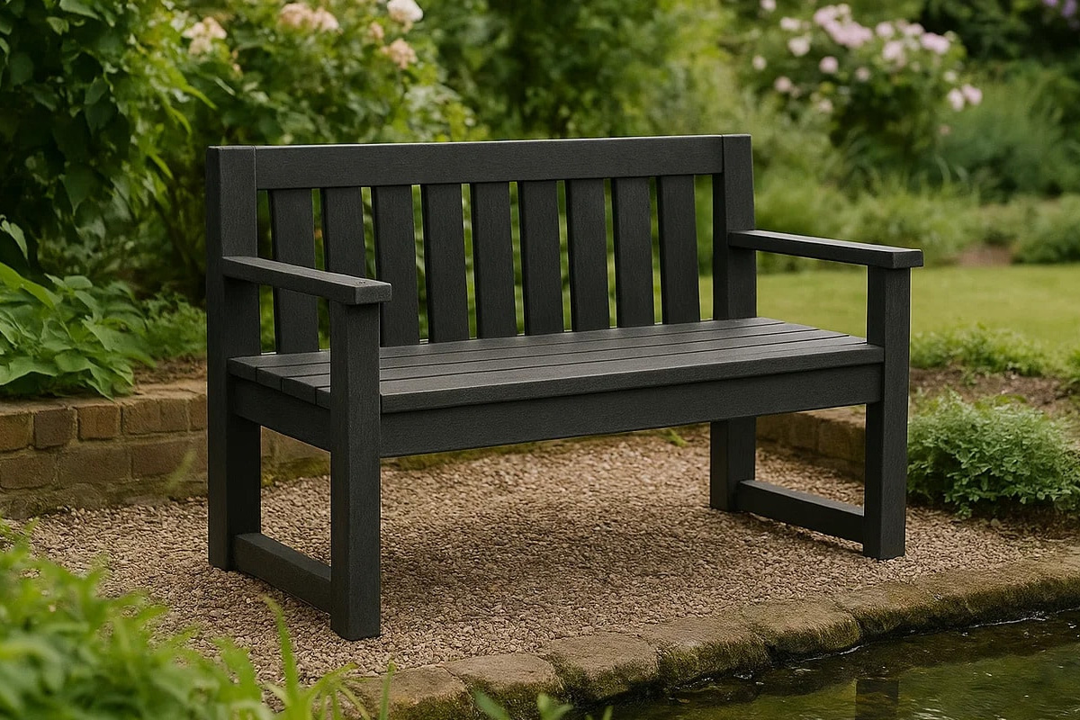 Black recycled plastic garden bench beside a pond surrounded by greenery, showing the benefits of recycled plastic benches in outdoor spaces.