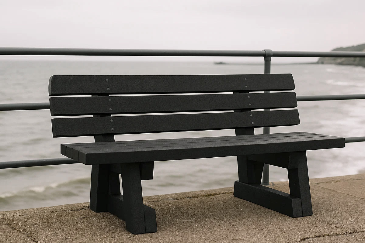 Recycled plastic bench on a coastal promenade overlooking the sea, showing durability and weather resistance in harsh conditions.