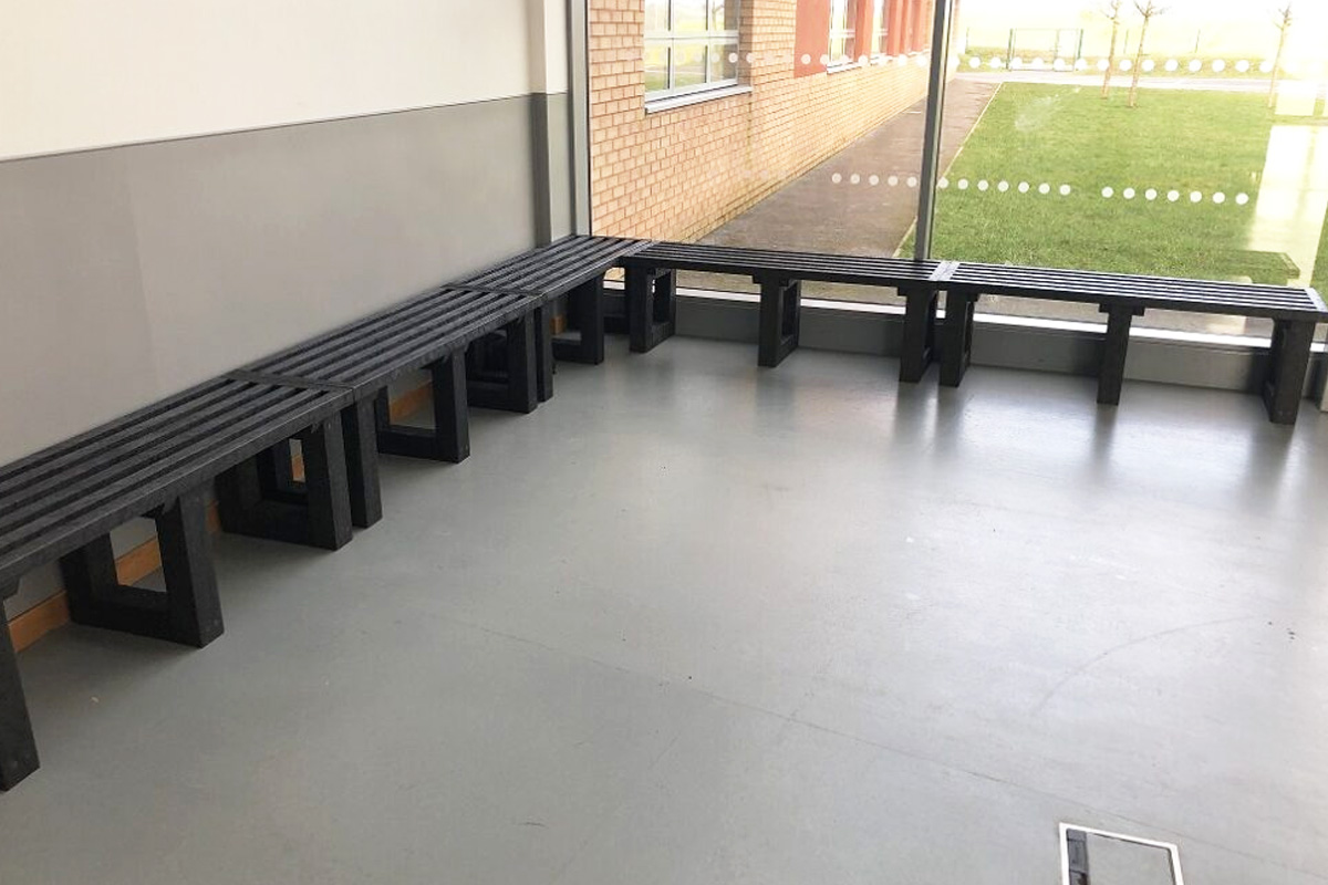 Recycled plastic benches arranged in a school hallway, illustrating practical, durable seating for educational settings.